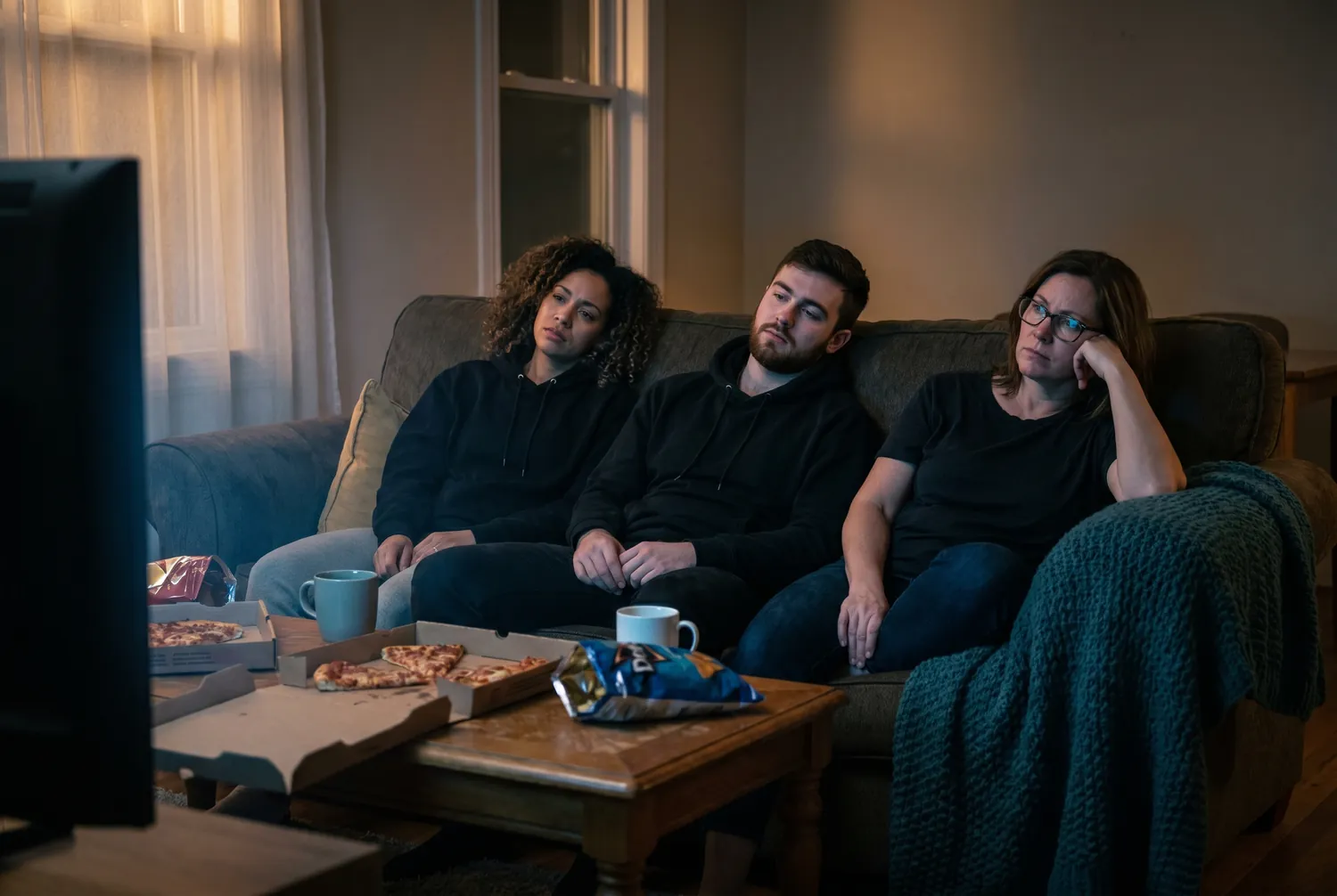 Three disappointed friends on a couch reacting to their team losing the big game