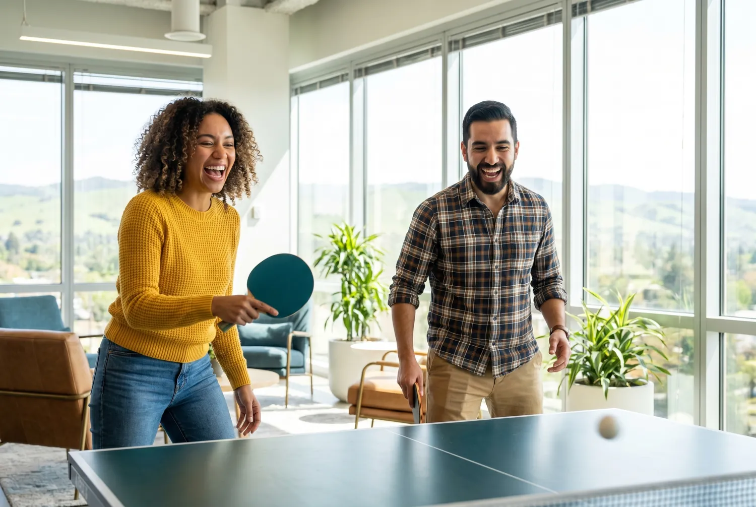 Coworkers playing ping pong in a sunlit San Jose office lounge Coworkers playing ping pong in a sunlit San Jose office lounge